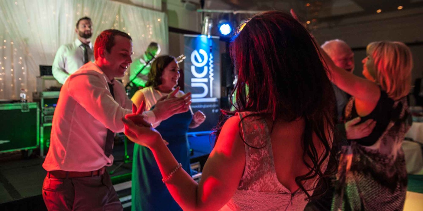 Photo of a woman playing air guitar at a Juice wedding