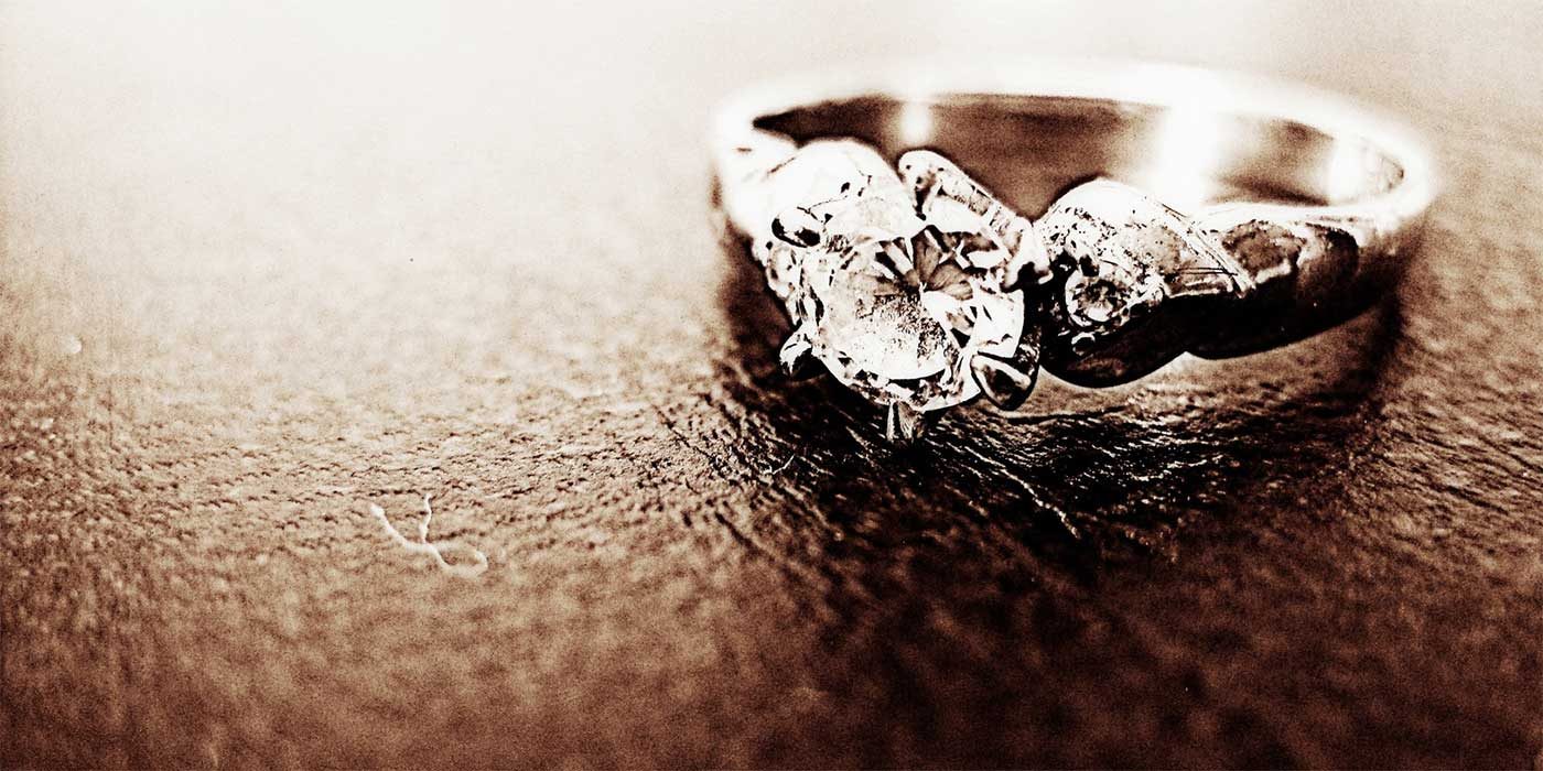 Photo of an engagement ring sitting on leather