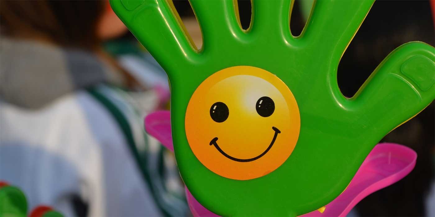 Photo of a toy hand with a happy face sticker