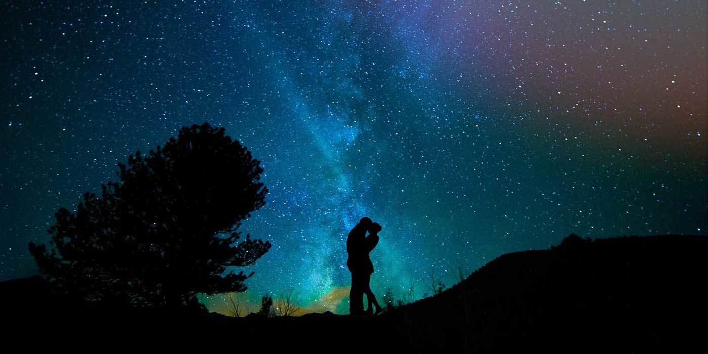Photo of a couple in front of a night sky with stars