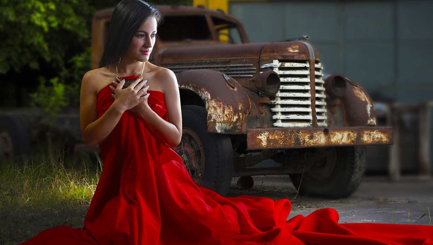 Photo of a lady in a red dress in front of a pickup