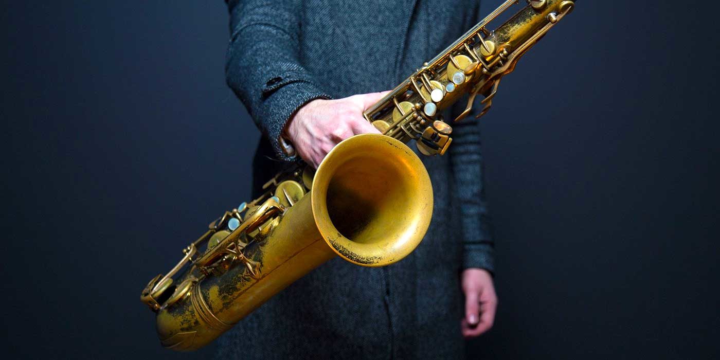 Photo of a musician holding a saxophone
